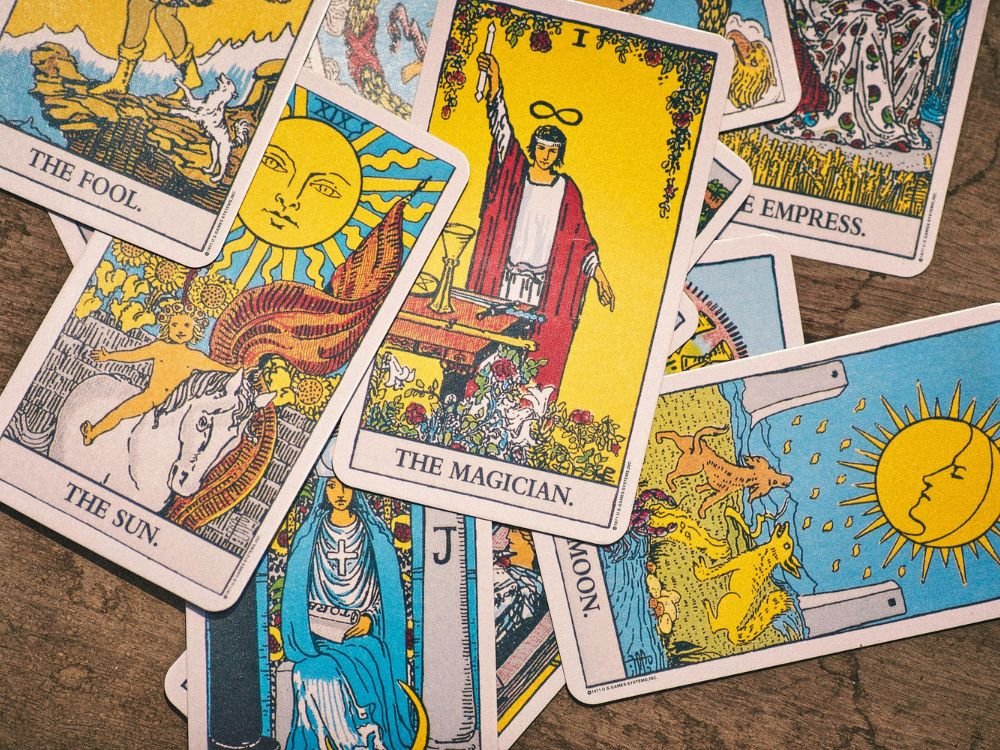Cartas do Tarot de Waite espalhadas sob uma mesa de madeira.